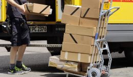 Kampf gegen Dumpingloehne bei Paketboten Archivfoto Paketbote Paketzusteller bei der Arbeit DHL Pa